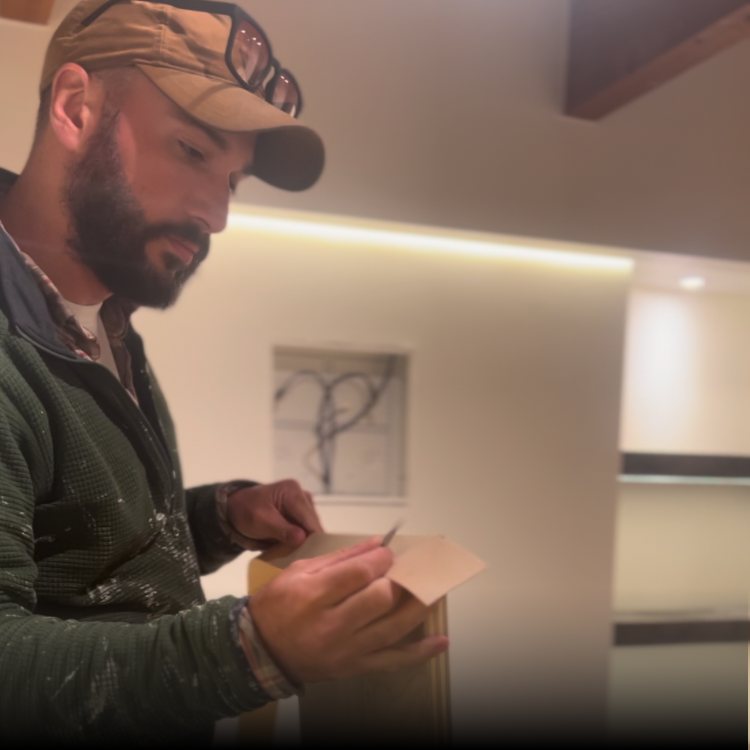 Emmanuel Forge on a jobsite in work clothes, writing on a document